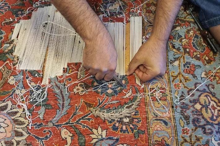 Deux mains sur la même tête de tapis : à deux, la chaîne reste droite.
