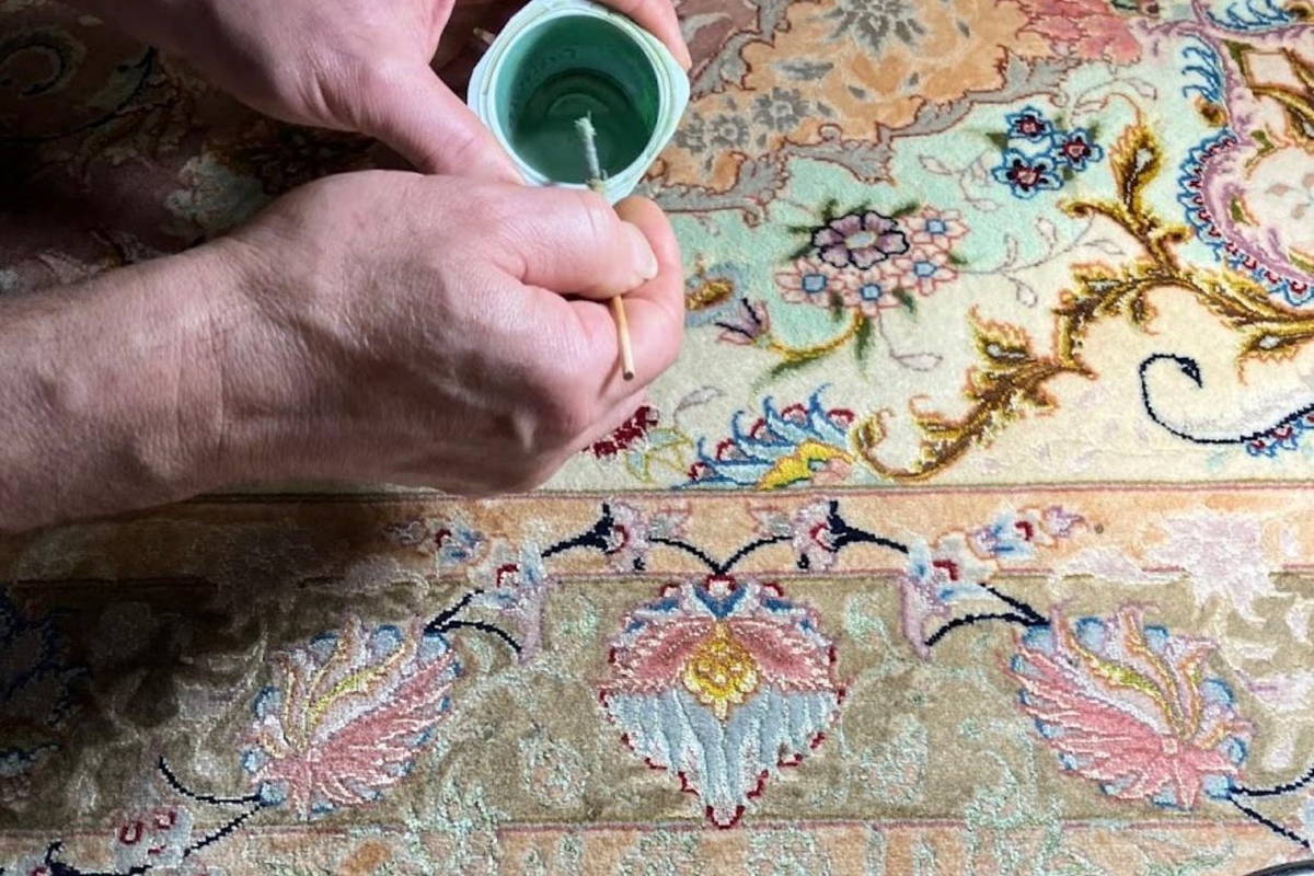 Le godet de teinture posé à même le tapis : la couleur se juge sur la pièce, jamais sur un nuancier.